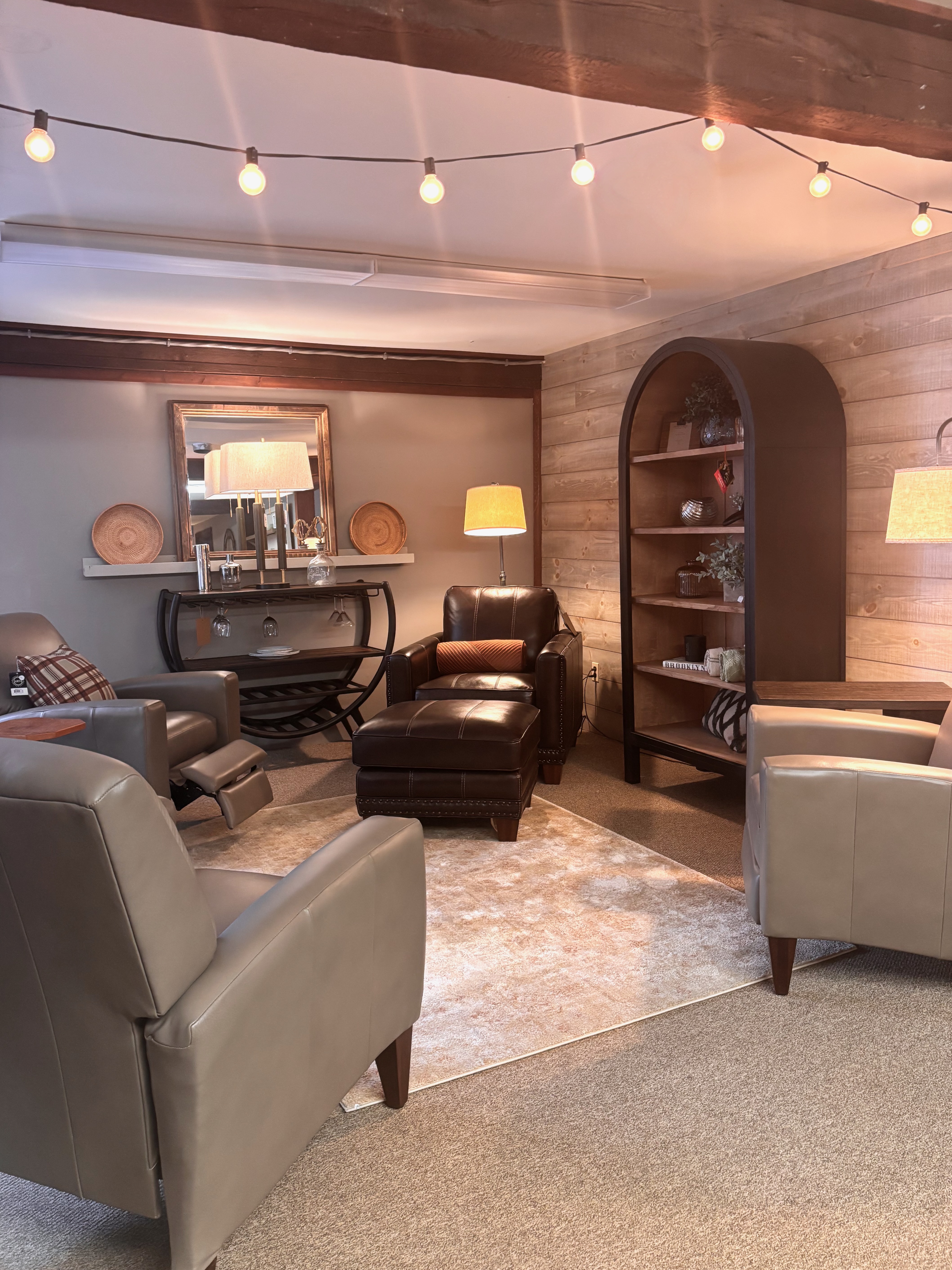 Perry's Home Furnishings & Design showroom with a wood accent wall with four leather chairs